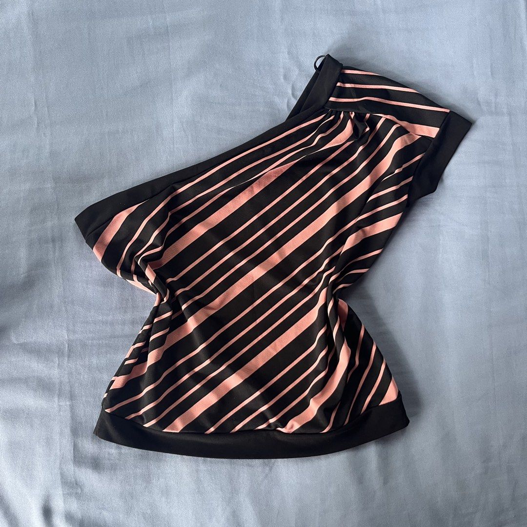 Black and Pink Striped One-Shoulder Blouse (Category: Blouses) located in Bocaue. Submitted by frankie_1818 (Listing ID 1470189185, Image 2). Description: - Design: Stylish one-shoulder with a single sleeve and wide black hem - Pattern: Bold diagonal pink stripes on a black background - Fit & Fabric: Relaxed fit made from smooth, comfortable material - Occasion: Ultimate statement piece for parties and going out - Condition: Brand new / Excellent