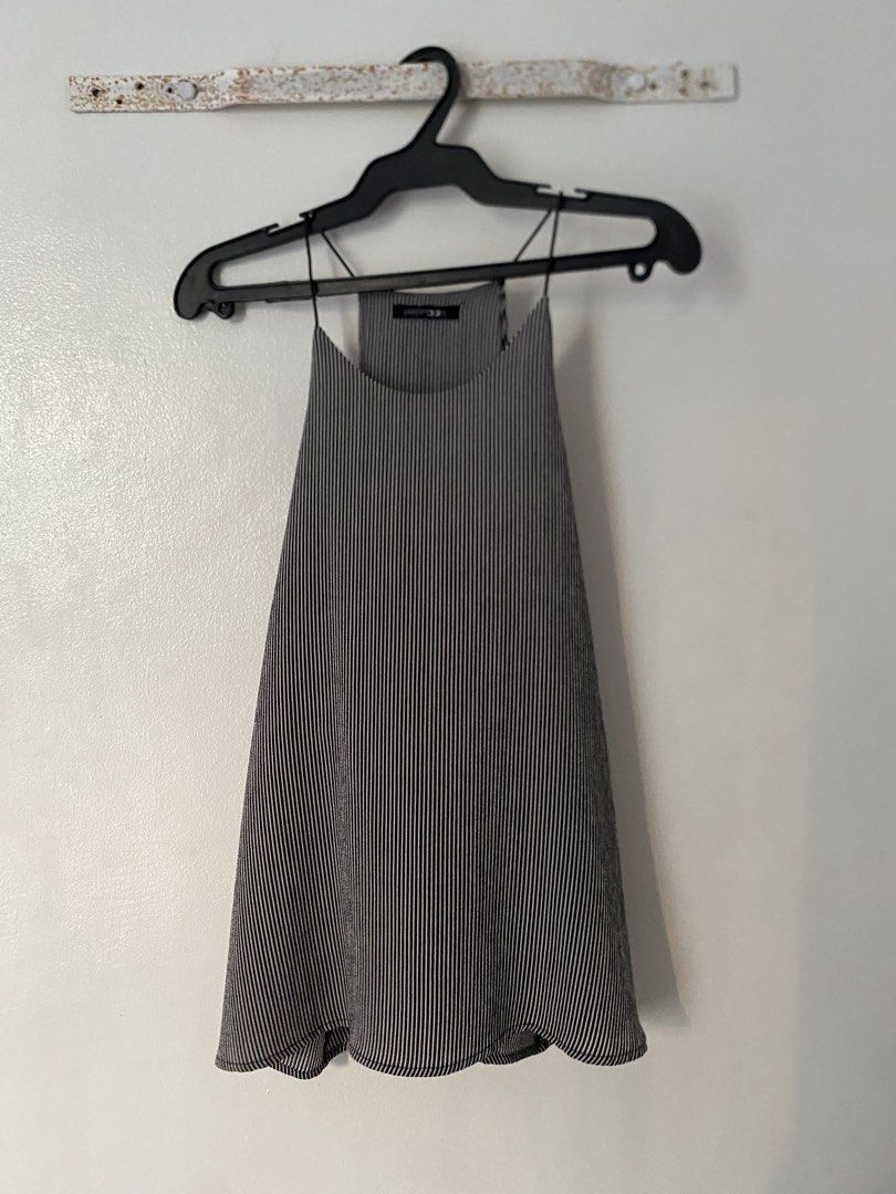 Black and White Striped Spaghetti Strap Tank Top (Category: Sleeveless) located in Caloocan City. Submitted by juliana_25a (Listing ID 1470232997, Image 1). Description: - Style: Black and white vertical pinstripe tank top - Design: Thin spaghetti straps, high halter neckline, and flowing relaxed hem - Material: Lightweight, breathable pleated fabric (super comfortable for warm weather).