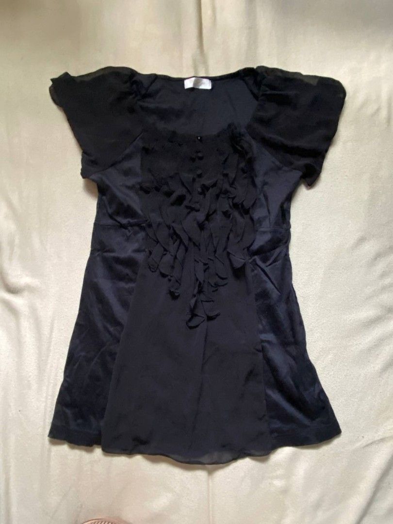 Black blouse with ruffle front detailing and short sleeves (Category: Blouses) located in Iloilo. Submitted by xya.xoxo28 (Listing ID 1470312161, Image 1). Description: - Color: Black - Style: Short-sleeve blouse with cascading ruffle front and button-down closure - Details: Sheer sleeves and paneling, scoop neckline - Fit: Standard fit, lightweight fabric - Versatility: Easily dresses up for work or pairs casually with jeans - Condition: Brand n