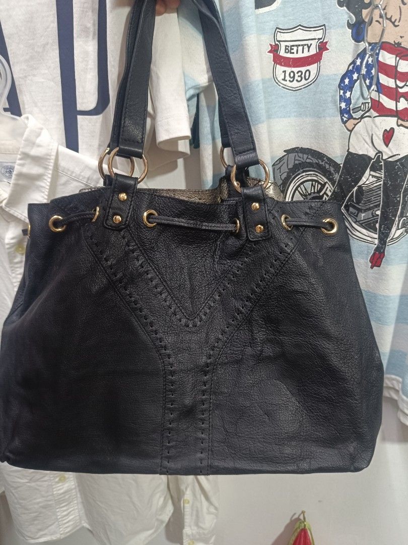 Black Leather Tote Bag with Gold Hardware (Category: Tote Bags) located in Pateros City. Submitted by harry062182 (Listing ID 1470220565, Image 1). Description: - Color: Black with chic gold-tone hardware (rings and studs) - Material: Textured leather with statement Y-stitch design on the front - Closure: Drawstring top with a thin leather tie - Straps: Double shoulder straps attached with metal rings - Interior: Spacious and roomy, ideal for eve