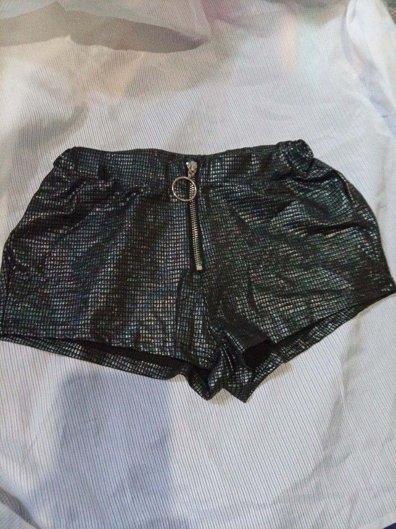 Black metallic textured shorts with front zipper ring (Category: Shorts) located in Manila. Submitted by tinygazo90639 (Listing ID 1470218537, Image 1). Description: - Color: Black with a shiny grid pattern texture - Closure: Front zipper with a statement large round ring pull - Waist: High waist fit with a comfortable elastic waistband at the back - Fabric: Slightly stretchy material for easy movement - Vibe: Perfect for parties, raves, and club