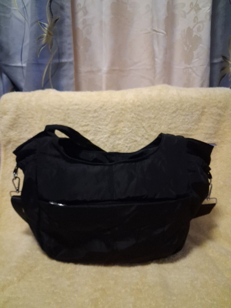 Black Nylon Shoulder Bag with Adjustable Strap (Category: Shoulder Bags) located in Angeles City. Submitted by anneps (Listing ID 1470217144, Image 2). Description: - Color: Black - Material: Durable, easy-to-clean nylon with sturdy metal hardware - Straps: Dual top handles and a detachable, adjustable crossbody strap - Storage: Spacious main compartment with a secure zip-top closure - Organization: Multiple exterior slip pockets for quick access