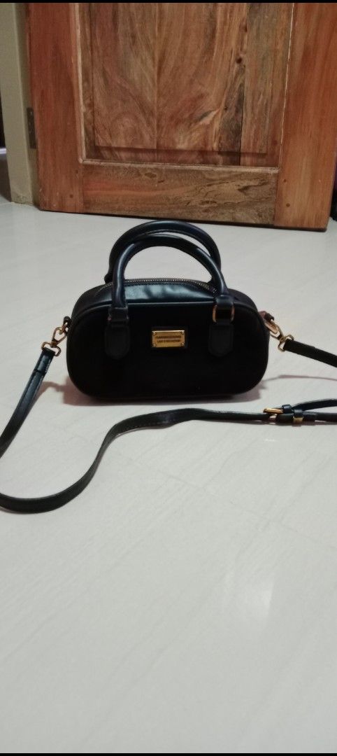 Black Suede Handbag Shoulder Bag (Category: Shoulder Bags) located in Mangaldan. Submitted by closetqwin (Listing ID 1470217909, Image 3). Description: - Color: Sleek black with a soft suede texture - Hardware: Premium gold-toned metal with a front branding plate Fashion Accessories Lady's Collection" - Versatility: Includes top handles and an adjustable/removable shoulder strap - See picture 9 for minimal flaws .