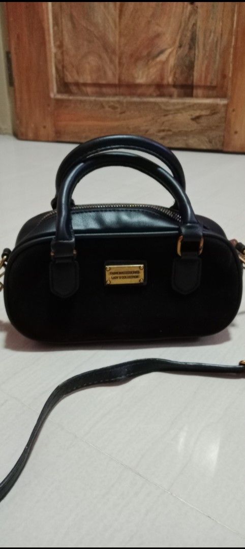 Black Suede Handbag Shoulder Bag (Category: Shoulder Bags) located in Mangaldan. Submitted by closetqwin (Listing ID 1470217909, Image 2). Description: - Color: Sleek black with a soft suede texture - Hardware: Premium gold-toned metal with a front branding plate Fashion Accessories Lady's Collection" - Versatility: Includes top handles and an adjustable/removable shoulder strap - See picture 9 for minimal flaws .