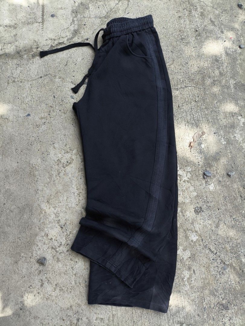 Black Sweatpants with Side Stripes and Drawstring Waist (Category: Joggers) located in Manila. Submitted by maryaganda (Listing ID 1470192978, Image 2). Description: - Color: Black - Fit: Relaxed fit with wide legs - Material: Soft cotton, super comfortable - Features: Elastic waistband with thick black drawstring, two front pockets, and stylish side stripe panels - Condition: Pre-loved with natural fading on the fabric and stripes from washing -