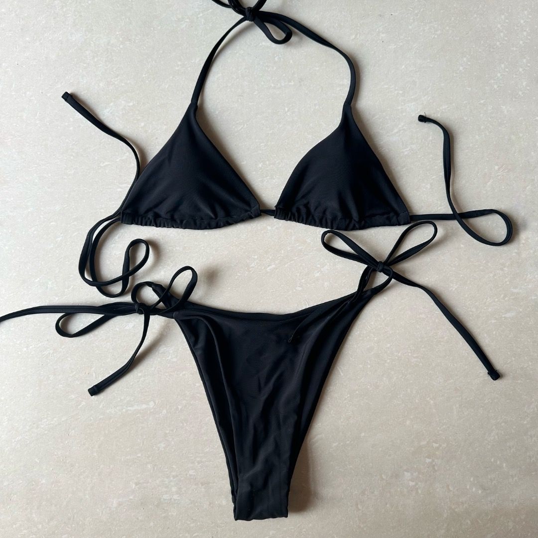 Black Triangle String Bikini (Category: Bikinis & Swimsuits) located in Paranaque City. Submitted by yanie.ae (Listing ID 1470166246, Image 2). Description: - Color: Classic black - Style: Minimalist string bikini set - Top: Adjustable sliding triangle cups - Bottoms: Matching side-tie for a customizable fit - Condition: Clean fabric, ready to wear - Perfect for: Beach trips, vacations, and pool days.