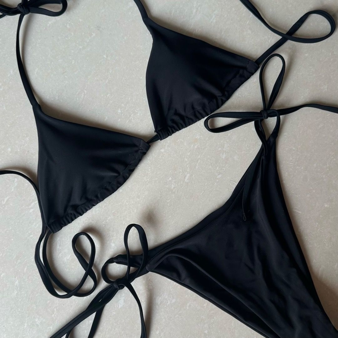 Black Triangle String Bikini (Category: Bikinis & Swimsuits) located in Paranaque City. Submitted by yanie.ae (Listing ID 1470166246, Image 1). Description: - Color: Classic black - Style: Minimalist string bikini set - Top: Adjustable sliding triangle cups - Bottoms: Matching side-tie for a customizable fit - Condition: Clean fabric, ready to wear - Perfect for: Beach trips, vacations, and pool days.