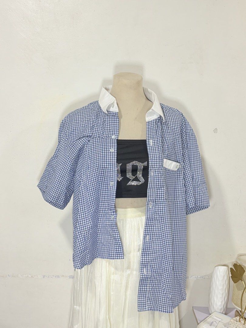 Blue and White Gingham Button-Up Shirt (Category: Blouses) located in Manila. Submitted by biacakes (Listing ID 1470264118, Image 2). Description: - Blue and white gingham pattern - Contrast white collar and pocket detail - Short sleeves with a relaxed fit - Fits up to size 2XL - Versatile casual top, perfect for layering or wearing on its own.
