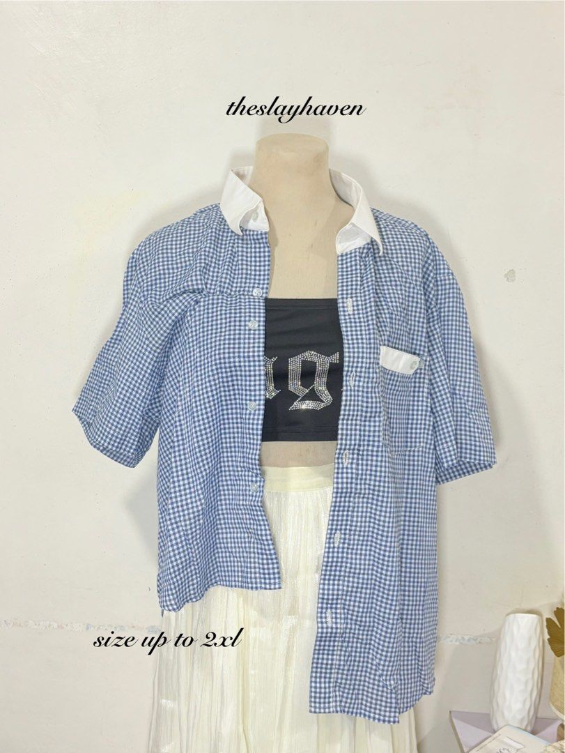 Blue and White Gingham Button-Up Shirt (Category: Blouses) located in Manila. Submitted by biacakes (Listing ID 1470264118, Image 1). Description: - Blue and white gingham pattern - Contrast white collar and pocket detail - Short sleeves with a relaxed fit - Fits up to size 2XL - Versatile casual top, perfect for layering or wearing on its own.