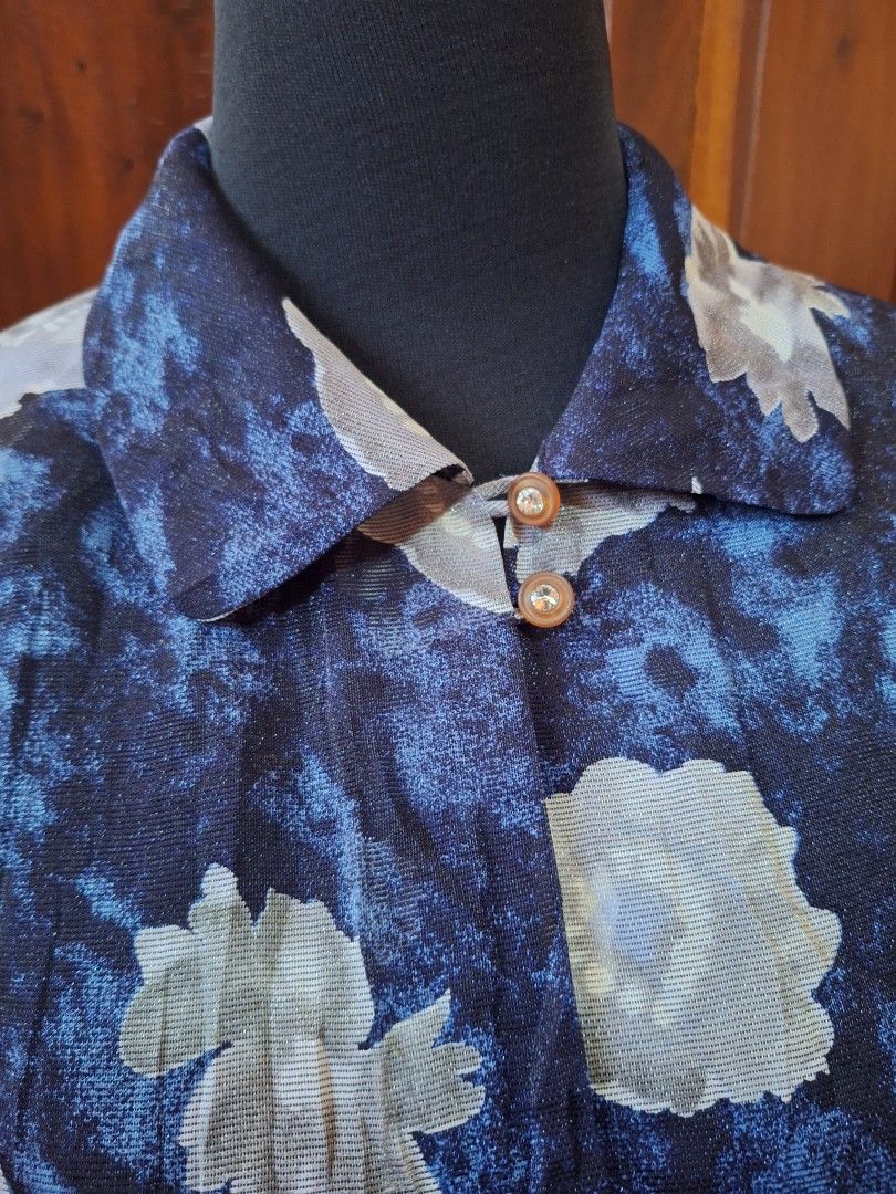 Blue floral sheer long sleeve button blouse (Category: Longsleeves) located in Balamban. Submitted by ubethan (Listing ID 1470214519, Image 2). Description: - Color & Pattern: Navy blue with an all-over white floral print - Fabric: Sheer, lightweight, and breathable material - Design: Long sleeves, collared neckline, and open front drape style - Details: Two small crystal-accented buttons near the collar - Styling: Versatile piece, great for laye