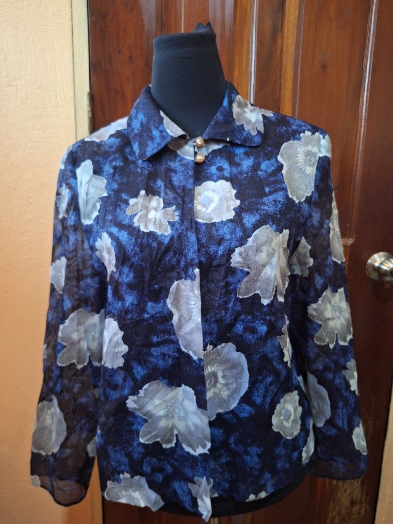 Blue floral sheer long sleeve button blouse (Category: Longsleeves) located in Balamban. Submitted by ubethan (Listing ID 1470214519, Image 3). Description: - Color & Pattern: Navy blue with an all-over white floral print - Fabric: Sheer, lightweight, and breathable material - Design: Long sleeves, collared neckline, and open front drape style - Details: Two small crystal-accented buttons near the collar - Styling: Versatile piece, great for laye