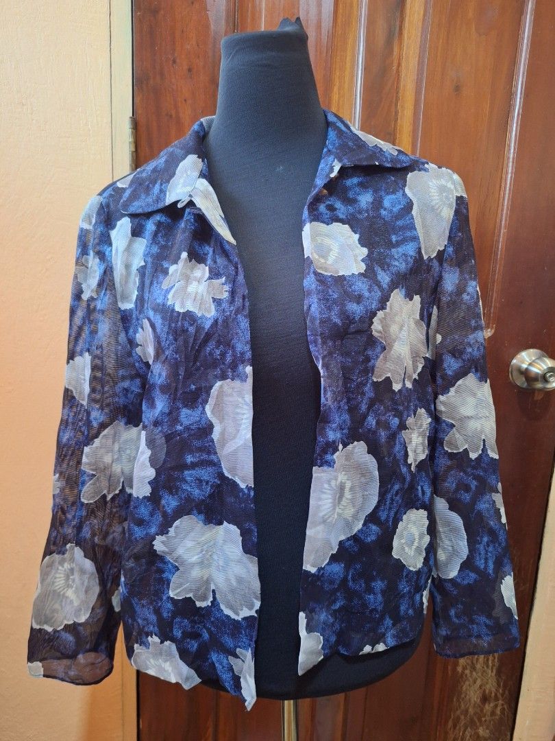 Blue floral sheer long sleeve button blouse (Category: Longsleeves) located in Balamban. Submitted by ubethan (Listing ID 1470214519, Image 1). Description: - Color & Pattern: Navy blue with an all-over white floral print - Fabric: Sheer, lightweight, and breathable material - Design: Long sleeves, collared neckline, and open front drape style - Details: Two small crystal-accented buttons near the collar - Styling: Versatile piece, great for laye