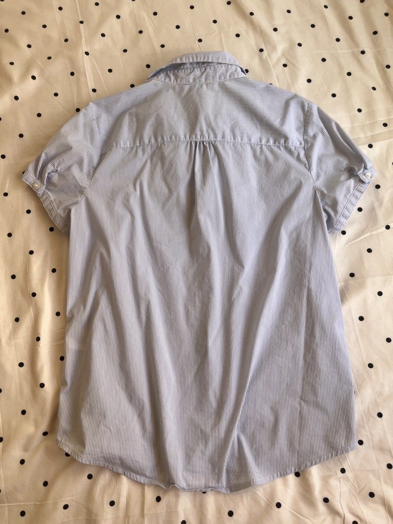 Blue striped short sleeve button-up shirt (Category: Blouses) located in Manila. Submitted by chimcheese (Listing ID 1470151861, Image 2). Description: - Style: Classic blue and white pinstripe short-sleeve shirt - Design: Point collar, front button closure, curved hem, and back pleat for easy movement - Fabric: Lightweight and breathable - Fit: Standard fit - Versatility: Ideal for office wear or smart casual outfits.