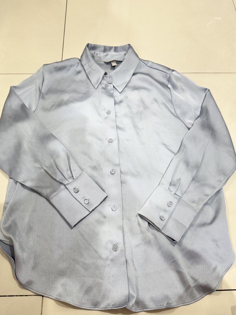 Blue-Gray Textured Button-Down Shirt (Category: Blouses) located in Manila. Submitted by buymiclothes.47 (Listing ID 1470336450, Image 1). Description: H&M Blue-Gray Textured Button-Down Shirt | M Preloved H&M long-sleeve button-down shirt in a pretty light blue-gray shade with a subtle sheen 🩵 * Size M * Slightly shiny, textured fabric * Classic collar and button-front closure * Long sleeves with button cuffs * Relaxed fit with curved hem * App