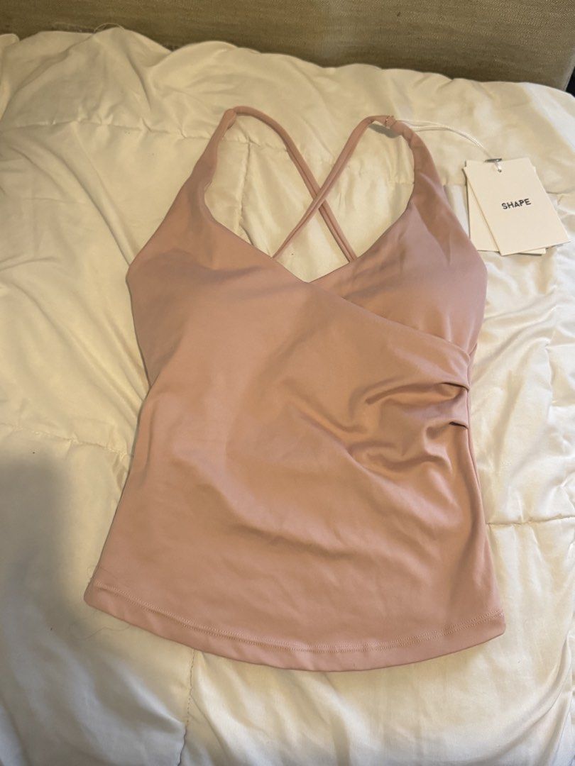 BNWT Shape Tone Cross Back Tank Top Rose Size S (Category: Sleeveless) located in Pasig City. Submitted by vanillaice__ (Listing ID 1470244032, Image 3). Description: - Brand New with tags - Color: Rose pink - Size: Small (Brand new with tags attached) - Design: Wrap front V-neck with trendy criss-cross straps in the back - Material: Soft, stretchy, and ultra-comfortable fabric - Details: Subtle brand logo printed near the lower back - Condition: