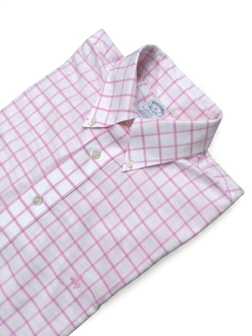 Brooks Brothers Pink White Plaid Button Down Shirt (Category: Tshirts & Polo Shirts ) located in Caloocan City. Submitted by wan_l_as (Listing ID 1470218150, Image 1). Description: - Brand: Brooks Brothers - Pattern: Pink and white windowpane check - Style: Classic button-down collar with front placket and buttoned cuffs - Details: Signature embroidered logo on the chest, long sleeves, and curved hem - Condition: Clean fabric with bright, vibrant