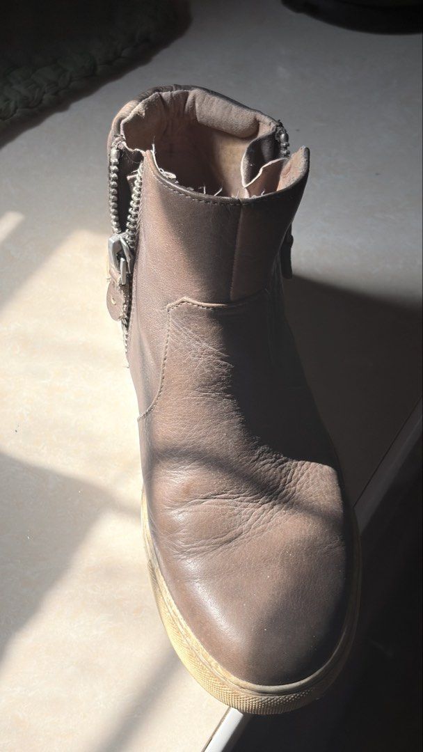 Brown leather ankle boots with side zippers (Category: Boots) located in Manila. Submitted by vexie.nyahmmy (Listing ID 1470209367, Image 2). Description: - Material: Brown leather with natural creasing on the toe box from wear - Sole: Comfortable sneaker-style rubber sole with minor scuff marks - Closure: Double side zippers equipped with convenient leather pull tabs - Design: Ankle height featuring a supportive padded collar - Usage: Versatile 