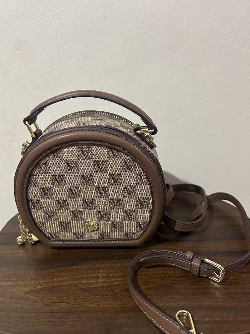 Brown Monogram Circle Crossbody Bag with Top Handle (Category: Cross-body Bags) located in Marilao. Submitted by bamito (Listing ID 1470166883, Image 1). Description: - Style: Round crossbody bag with checkered monogram print - Color: Brown with dark brown leather trim - Hardware: Gold-tone accents including top zipper closure - Straps: Includes a matching top handle and an adjustable shoulder strap .