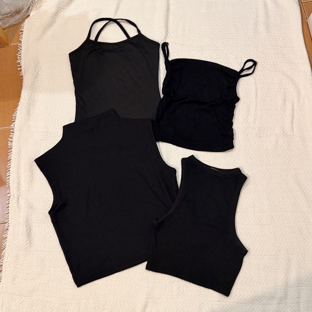 Bundle of 4 black tops and tanks (Category: Sleeveless) located in Makati City. Submitted by banshee1411 (Listing ID 1470253452, Image 1). Description: Bundle of 4 essential black tops - ribbed mock neck sleeveless top - racerback crop top - camisole with criss-cross back straps - ruched spaghetti strap top .
