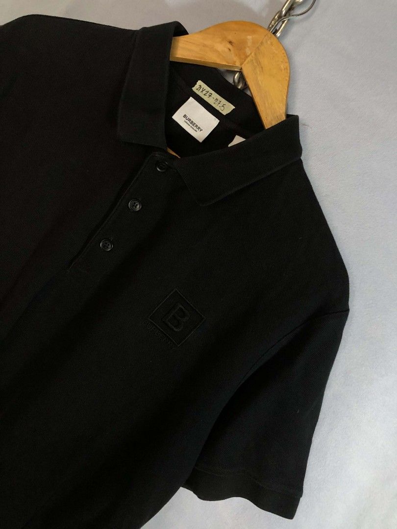 Burberry Black Polo Shirt (Category: Tshirts & Polo Shirts ) located in Caloocan City. Submitted by oldmoneyoutfit24 (Listing ID 1470234085, Image 2). Description: - Authentic Burberry black polo shirt - Classic pique cotton material for all-day comfort - Subtle tonal black 'B' monogram embroidered patch on chest - Standard collar with a 3-button branded placket - Versatile and easy to style for smart-casual looks - Size and measurements found on