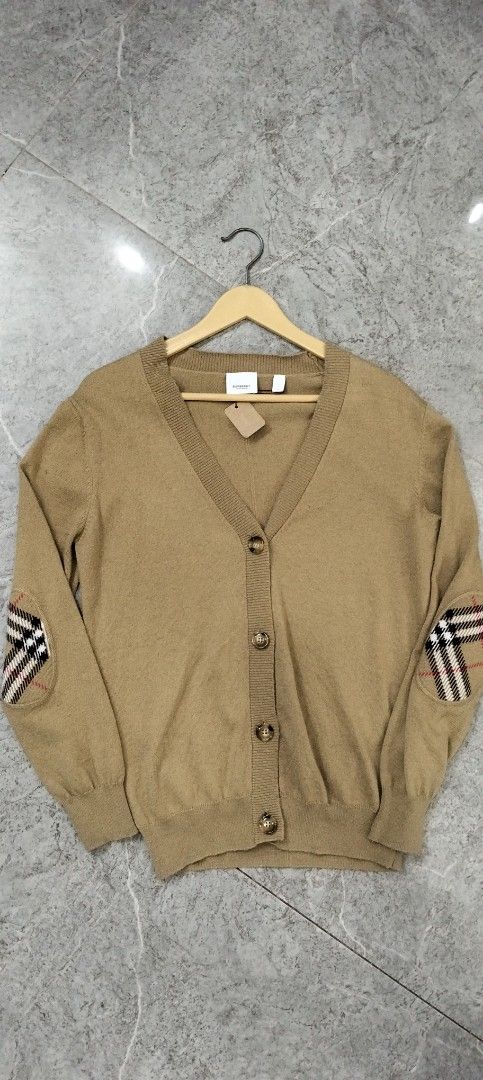 Burberry Check Elbow Patch V-Neck Cardigan Camel (Category: Coats, Jackets and Outerwear) located in Manila. Submitted by hurleydediamante0513 (Listing ID 1470169403, Image 1). Description: - Brand: Burberry - Color: Classic camel - Style: V-neck with front button closure - Design Detail: Signature check pattern patches on both elbows - Finish: Ribbed cuffs and hem for a snug fit - Authenticity: Includes brand tag at inner collar and official car