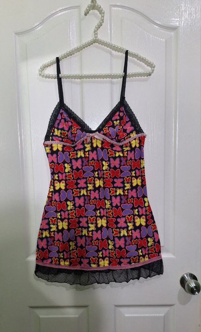 Butterfly pattern lingerie dress medium D12 (Category: Undergarments & Loungewear) located in San Pablo. Submitted by allyourbrandedneeds (Listing ID 1470145005, Image 2). Description: - Design: All-over colorful butterfly pattern on a black base - Neckline: V-neck with delicate black lace trim - Straps: Adjustable shoulder straps for a custom fit - Details: Cute pink ruffled ribbon accent on the chest - Hem: Sheer dotted mesh ruffle layer - Cond