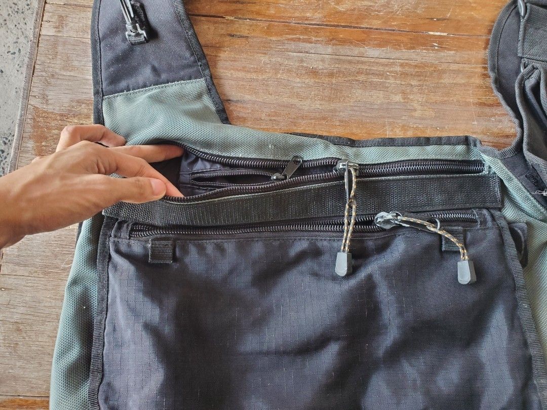 Camel Bag Black Multi-Pocket Messenger Sling Bag (Category: Sling Bags) located in Cavite. Submitted by kyzqway (Listing ID 1470208727, Image 2). Description: Black and green crossbody bag from Camel Bags. Built with tons of storage compartments, including dual front zippered pockets, extra pouches under the main flap, and a small utility pouch on the shoulder strap. Headphone cord pass-through rubber eyelet near the top strap. Heavy-duty black h
