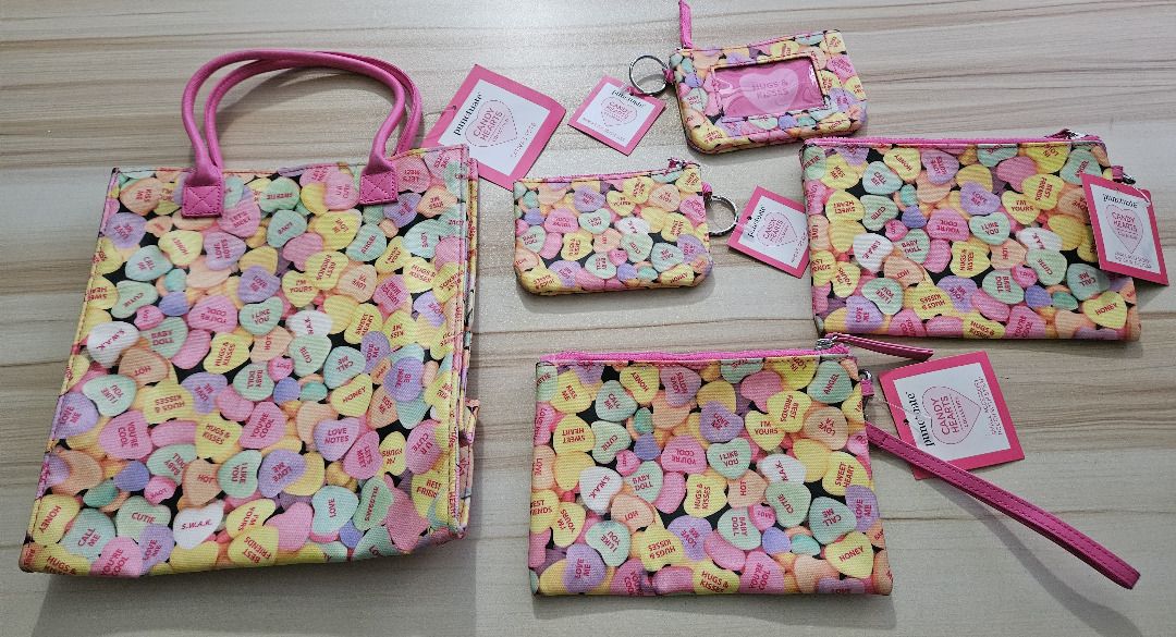 Candy Hearts Set (Category: Purses & Pouches) located in Makati City. Submitted by KuWeLaDevil01 (Listing ID 1470230855, Image 1). Description: I am liking this AI generation tool, but it's not really my tone, anyway... - Punctuate Candy Hearts Collection - Colorful candy hearts print on black background with pink trim - Bundle includes: 1 Tote bag with pink handles 2 Zip pouches with key rings & ID window pouch 2 Wristlet pouches - Several items