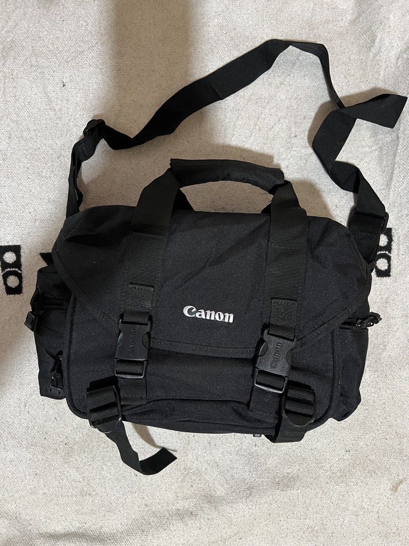Canon Black Camera Bag Shoulder Bag (Category: Camera Bags & Carriers) located in Cagayan de Oro. Submitted by nelsondel21723 (Listing ID 1470232471, Image 1). Description: - Genuine black Canon camera shoulder bag - Durable fabric with sturdy plastic buckles - Adjustable strap and convenient top handle - Multiple side zip pockets for accessories and memory cards - Rubberized bottom strips for scuff protection - dimension width 13 X 9 Length .