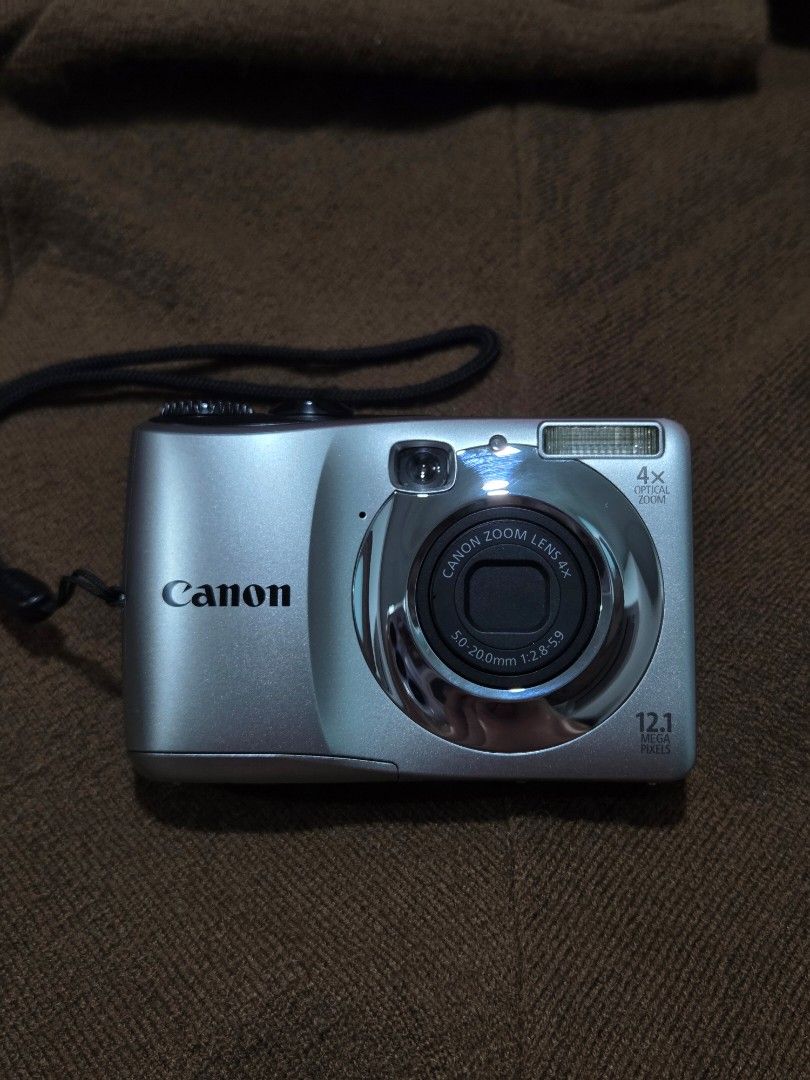 Canon PowerShot Digital Camera Bundle with Charger and Batteries (Category: Cameras) located in Quezon City. Submitted by mikaykie (Listing ID 1470305958, Image 1). Description: Canon PowerShot A1200 12.1 mega pixel Silver body Flash working Zoom working Includes battery charger and a case of four rechargeable batteries Tested and powers on Screen displays fine with screen burn SDHC Card, SD card with Adapter Wrist strap attached RFS: I realized 