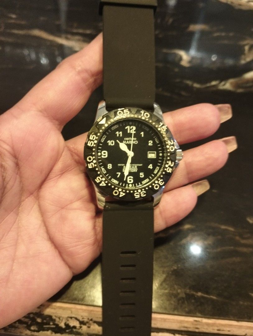 Capitano Marino Black Dial Quartz Wristwatch (Category: Men's Watches) located in General Mariano Alvarez. Submitted by ma.miafajardo1219 (Listing ID 1470298489, Image 1). Description: - Brand: Capitono Marino - Movement: Quartz with battery lifespan indicator - Dial: Black face with bold white numeric markings and date window at 3 o'clock - Bezel: Rotating bezel with minute numbers - Case: Silver-tone metal casing - Strap: Comfortable and adjust