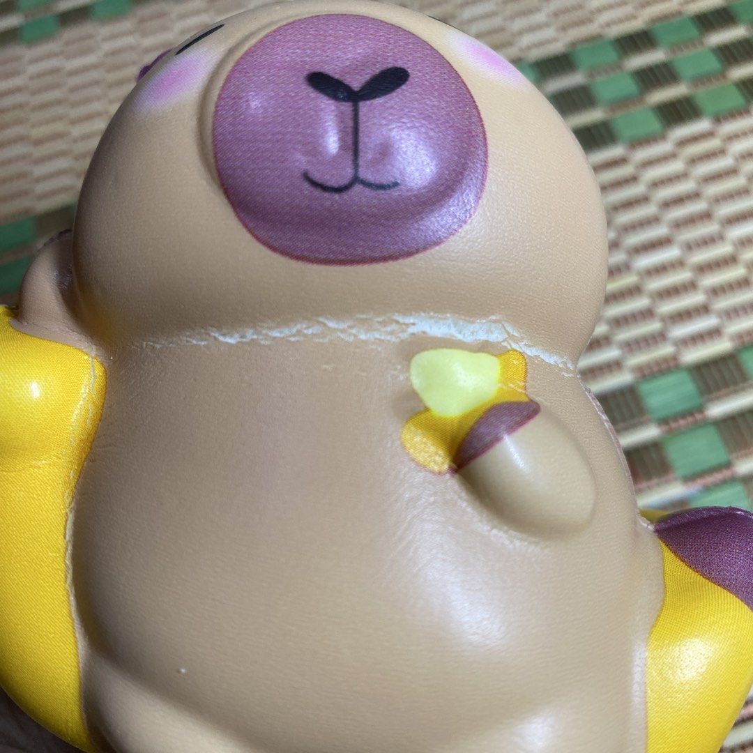 Capybara Eating Banana Squishy Toy (Category: Designer & Blind Box Toys) located in Apalit. Submitted by dimenheats (Listing ID 1470286592, Image 3). Description: Slow-rising foam Flaw note: Minor tear line under the chin area from squeezing.