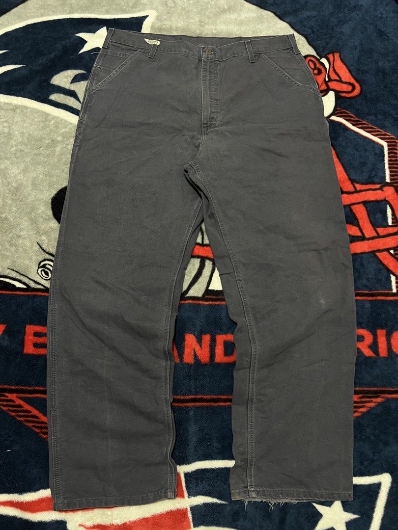 Carhaart Carpenter Work Pants Dark Grey (Category: Jeans) located in Tanza. Submitted by 1954_street (Listing ID 1470306871, Image 3). Description: CARHARTT CARPENTER PANTS 40 waist 45 length 10 leg opening minor tattered hem 1800 - Brand: Carhartt - Color: Dark Grey - Style: Classic carpenter work pants with metal button fly - Features: Utility pockets, side hammer loop, and woven brand patch on the back pocket - Condition: Genuine worn-in condi