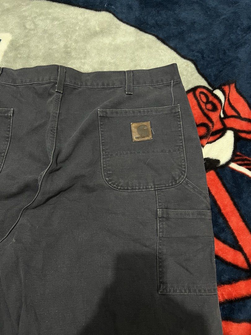 Carhaart Carpenter Work Pants Dark Grey (Category: Jeans) located in Tanza. Submitted by 1954_street (Listing ID 1470306871, Image 2). Description: CARHARTT CARPENTER PANTS 40 waist 45 length 10 leg opening minor tattered hem 1800 - Brand: Carhartt - Color: Dark Grey - Style: Classic carpenter work pants with metal button fly - Features: Utility pockets, side hammer loop, and woven brand patch on the back pocket - Condition: Genuine worn-in condi