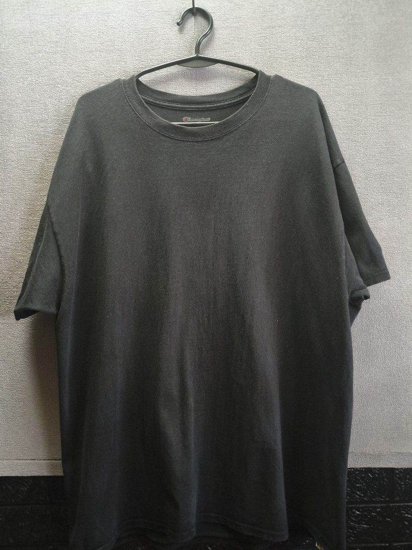 Champion Black T-Shirt (Category: Tshirts & Polo Shirts ) located in Buug. Submitted by zigeldz_a1721a (Listing ID 1470299901, Image 1). Description: - Brand: Champion - Color: Charcoal Black - Fit: Regular fit - Neckline: Classic crew neck - Sleeves: Short sleeves with signature embroidered logo patch on the left cuff - Style: Casual, athletic wear - Condition: Excellent / Pre-loved (ready to wear) - Pair it with: Jeans, shorts, or joggers for a
