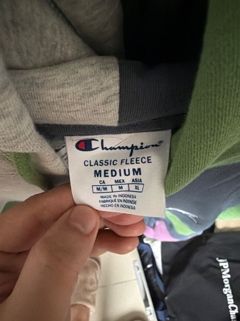 Champion Colorblock Patchwork Hoodie Sweatshirt (Category: Coats, Jackets and Outerwear) located in Taguig. Submitted by limarhermis (Listing ID 1470164406, Image 2). Description: - Brand: Champion - Style: Colorblock patchwork hoodie - Colors: Grey, green, dark blue, and purple panels - Material: Soft and warm fleece inside - Features: Adjustable green drawstrings, front kangaroo pocket, and classic embroidered chest logo - Fit: Pullover style.