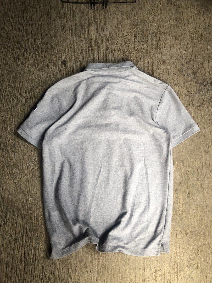 Championship polo men’s (Category: Tshirts & Polo Shirts ) located in Zamboanga. Submitted by wayne_geroche16 (Listing ID 1470309864, Image 2). Description: - Brand: NET men - Color: Grey - Size: Medium (Tagged M) -width: 19.5 -length: 25.5 - Design: Bold Championship United Club U.K. embroidery across the chest - Details: Shield logo patch on right chest, number 6 patch on left sleeve - Features: Classic collar with a three-button placket - Cond