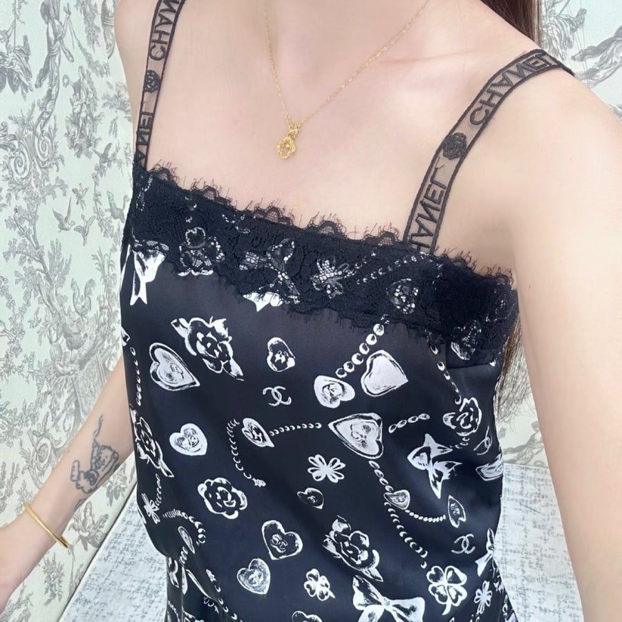 Chanel silk camisole top with prints size 38 small - medium (Category: Luxury Apparel) located in San Pablo. Submitted by allyourbrandedneeds (Listing ID 1470145062, Image 2). Description: - Brand: Chanel - Material: 100% Silk main fabric, cotton & polyamide braid - Design: Black and white heart, clover, and bow print - Details: Black lace trim at neckline, straps with branded Chanel lettering and floral accents - Fit: Adjustable tie hem at the b