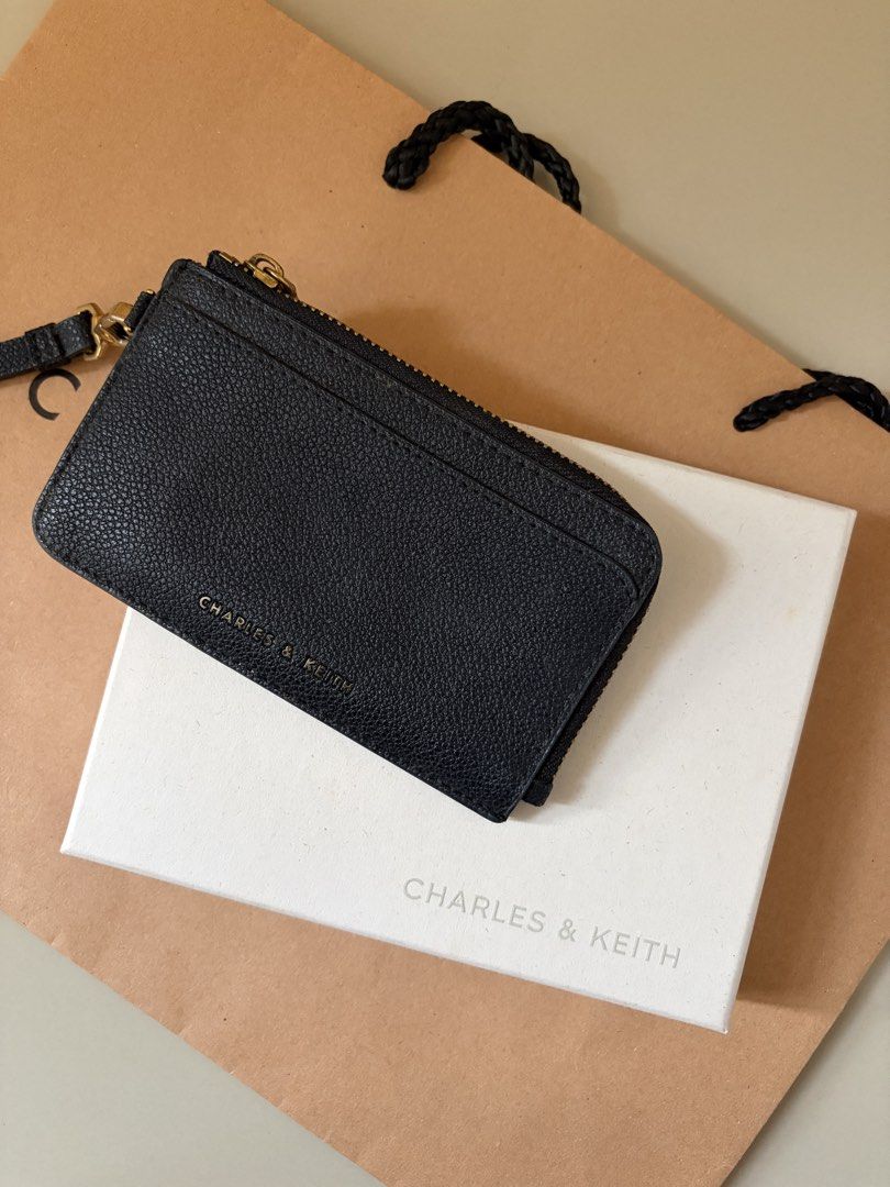 Charles & Keith Black Cardholder with Strap (Category: Wallets & Card holders) located in General Trias. Submitted by r_bimil (Listing ID 1470198273, Image 1). Description: Charles & Keith Black Cardholder with Strap for sale! - Features: Top zip closure, multiple card slots on the back, and a removable wrist strap - Inclusions: Complete with original box, paper bag, tag, and care card - Style Code: CK6-50770514-1.