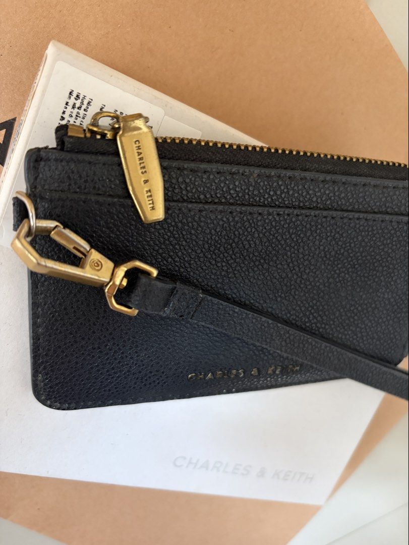 Charles & Keith Black Cardholder with Strap (Category: Wallets & Card holders) located in General Trias. Submitted by r_bimil (Listing ID 1470198273, Image 2). Description: Charles & Keith Black Cardholder with Strap for sale! - Features: Top zip closure, multiple card slots on the back, and a removable wrist strap - Inclusions: Complete with original box, paper bag, tag, and care card - Style Code: CK6-50770514-1.