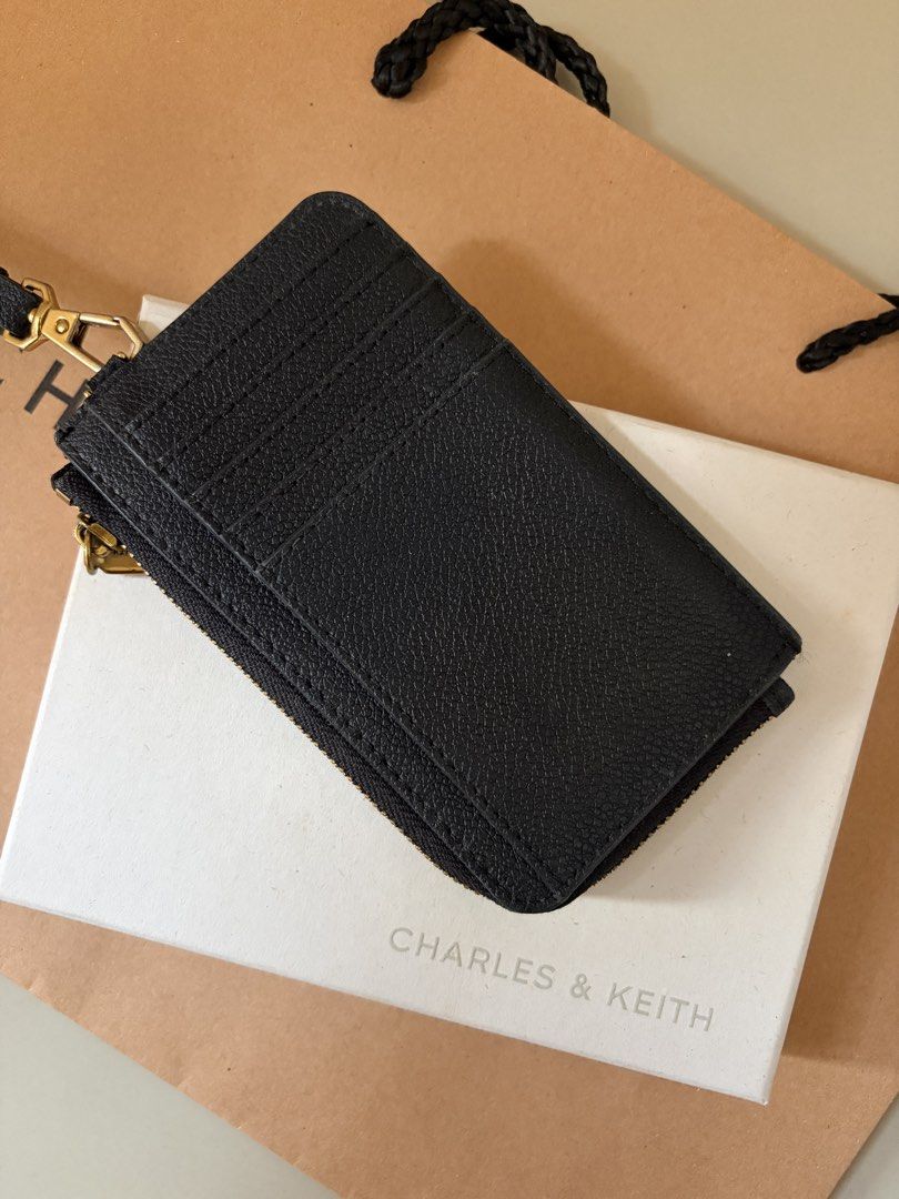 Charles & Keith Black Cardholder with Strap (Category: Wallets & Card holders) located in General Trias. Submitted by r_bimil (Listing ID 1470198273, Image 3). Description: Charles & Keith Black Cardholder with Strap for sale! - Features: Top zip closure, multiple card slots on the back, and a removable wrist strap - Inclusions: Complete with original box, paper bag, tag, and care card - Style Code: CK6-50770514-1.