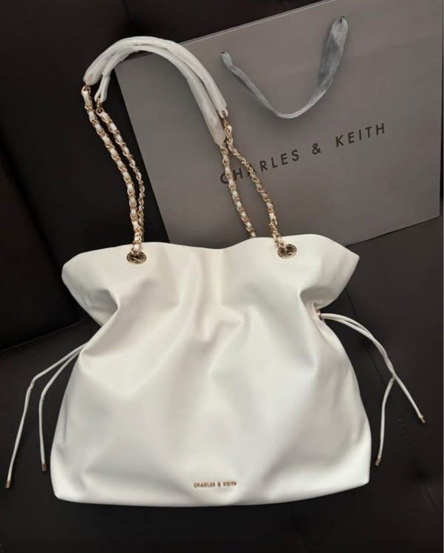 Charles & Keith White Slouchy Shoulder Bag with Chain Strap (Category: Shoulder Bags) located in Manila. Submitted by manilynpitero (Listing ID 1470143910, Image 1). Description: - Brand: Charles & Keith - Color: Classic White - Material: Soft faux leather with a trendy slouchy shape - Straps: Chic mixed gold-tone chain and white straps - Details: Cute side drawstring accents and small gold logo on the front - Shipping: Via J&T Express or Lalamov