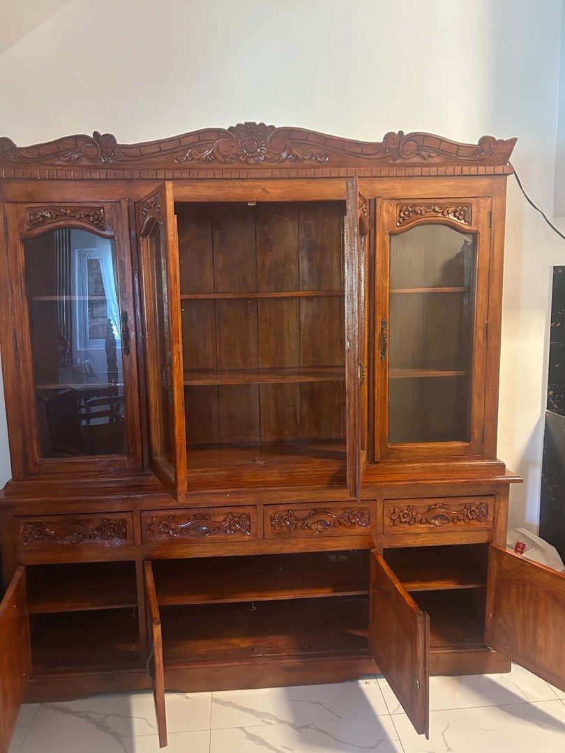 China Cabinet / Display Cabinet / Estante (Category: Shelves, Cabinets & Racks) located in Mandaluyong City. Submitted by l2ayne (Listing ID 1470210238, Image 2). Description: China Cabinet / Display Cabinet / Estante - Dimension: 6ft. Height 5ft. Width - Style: Classic traditional design with ornate floral carvings - Finish: Warm honey brown wood - Upper Section: 4 glass doors with internal wooden shelving - Lower Section: 4 spacious drawers and