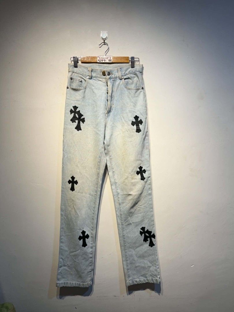 Chrome Hearts Cross Patch Light Wash Denim Jeans (Category: Jeans) located in Carmen. Submitted by kyntmiras_thrift (Listing ID 1470143617, Image 2). Description: - Style: Classic straight fit denim jeans - Wash: Light wash with natural fading - Details: Black leather cross patches on legs and back pockets - Hardware: Metal branded waist button and silver-tone engraved rear badge - Material: Sturdy twill fabric.