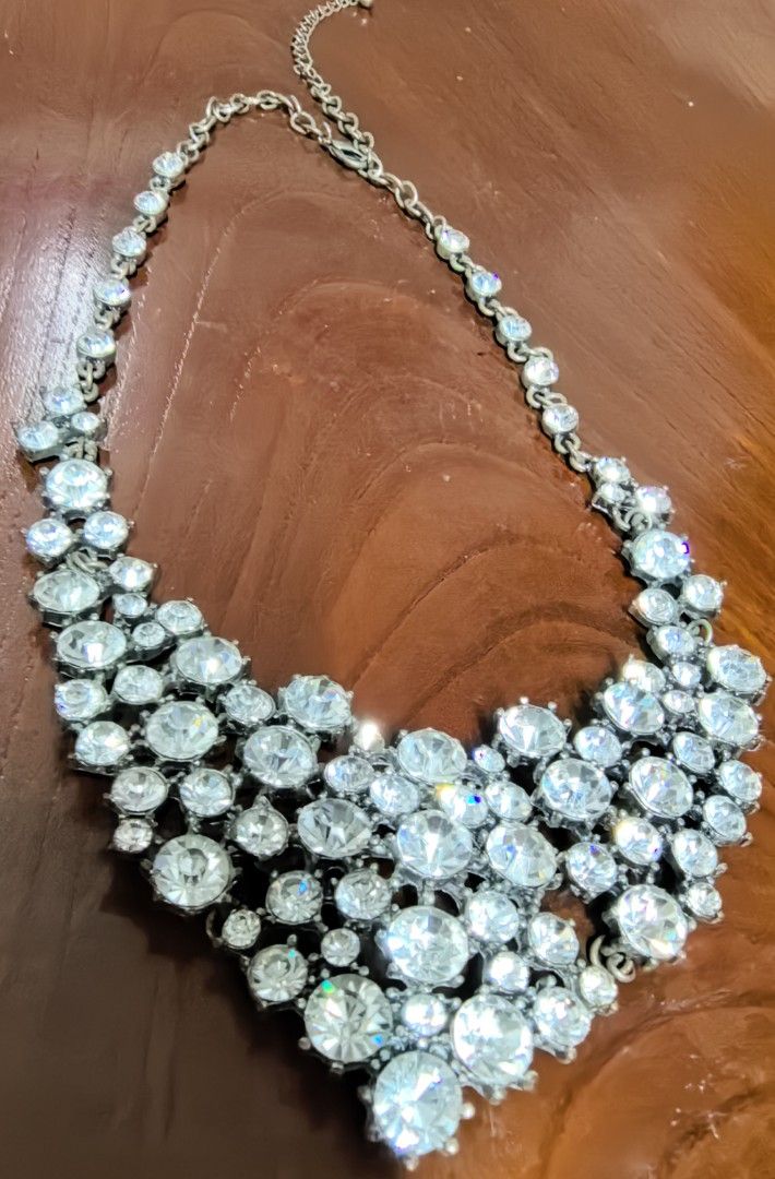 Chunky rhinestone statement collar necklace silver tone (Category: Necklaces) located in Rizal. Submitted by gkstcenit (Listing ID 1470344626, Image 1). Description: - Stunning multi-layered cluster design covered in sparkly clear rhinestones - Silver-tone metal backing with an adjustable chain and secure lobster clasp - Measures approximately 6 inches long from top to bottom - Perfect statement piece to elevate a plain top or evening dress.
