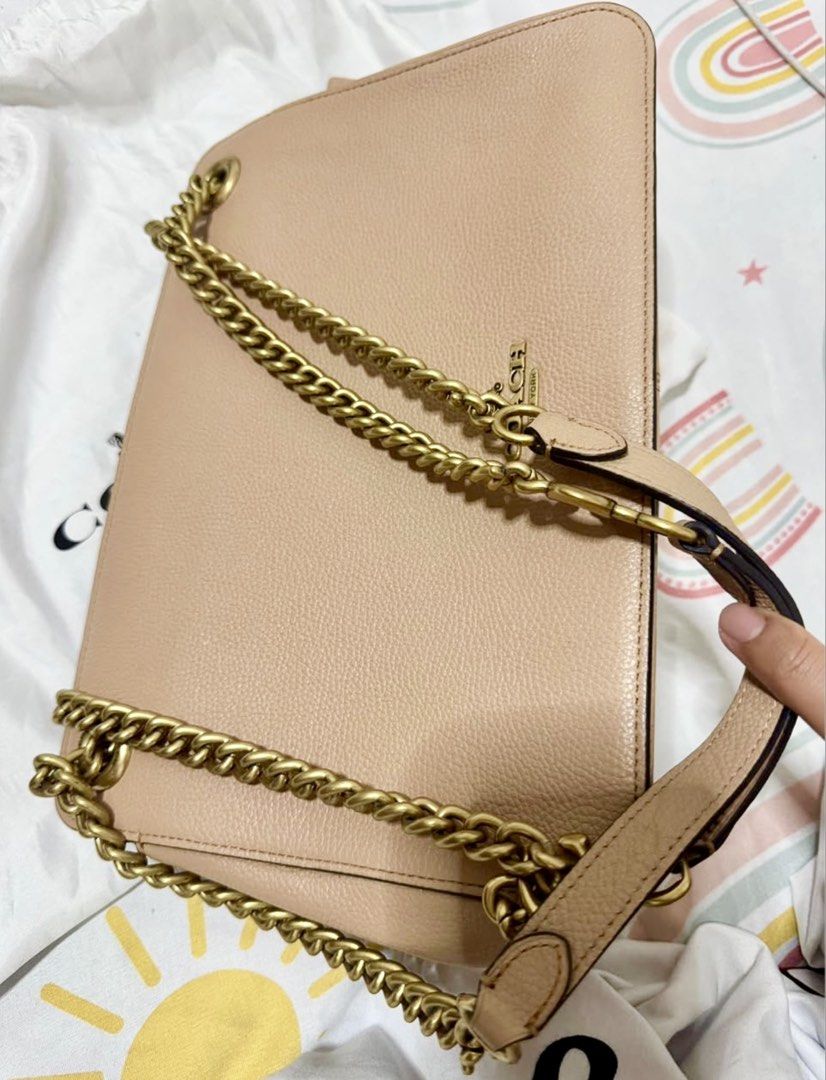 Coach Bryant Convertible Bag (Category: Luxury Bags & Wallets) located in Manila. Submitted by 95ybbrf8bx80014 (Listing ID 1470316895, Image 3). Description: - Brand: Coach - Color: Beige - Material: Textured leather - Hardware: Antique brass chain strap with leather shoulder guard & gold-tone logo lettering - Design: Structured rectangular shape with side gussets - Condition: Clean stitching details along edges and sides.