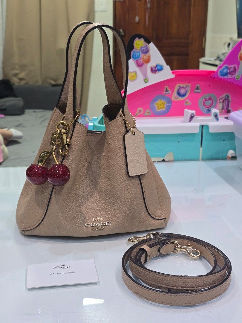 Coach Leather Shoulder Bag with Cherry Charm (Category: Luxury Bags & Wallets) located in Imus. Submitted by chie0308 (Listing ID 1470286296, Image 1). Description: - Authentic Coach pebbled leather bag in beige - Includes a detachable strap for versatile styling - Comes with a cute glittery red cherry bag charm - Features inside Coach story patch (N8 H1980-78800) and Made in Vietnam tag Like new, no issues. with FREE Coach cherry charm bag ‼️ Im