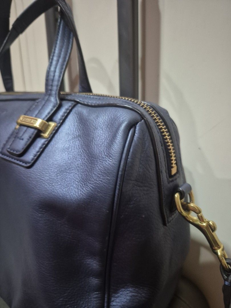 Coach Leather Shoulder Bag with Gold Hardware (Category: Luxury Bags & Wallets) located in Iloilo. Submitted by gorgeoustatz (Listing ID 1470288102, Image 2). Description: - Brand: Coach - Color: Dark blue or black - Material: Premium pebble texture leather - Hardware: Elegant gold-tone zippers and hardware - Branding: Debossed Coach logo on the front - Carry options: Dual top handles and a detachable strap with swivel clasp closure - Structure: 