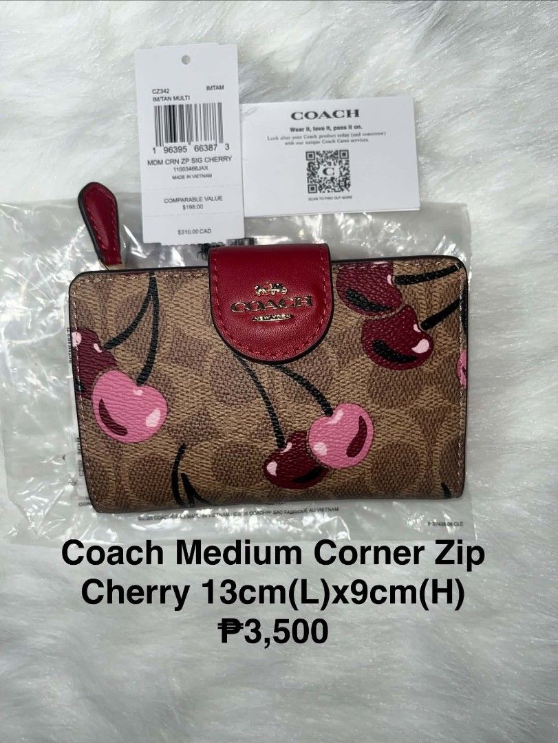 Coach Medium Corner Zip Signature Cherry Wallet IM/TAN MULTI (Category: Wallets & Card holders) located in Imus. Submitted by maria_pilayo (Listing ID 1470276385, Image 1). Description: - Coach - Brand new, never used, and stored in plastic packaging - 💯% Authentic Coach medium corner zip wallet in signature canvas with cherry print - Features rich red leather trim and gold-tone hardware - Compact size: 13cm x 9cm - Interior includes multiple ca