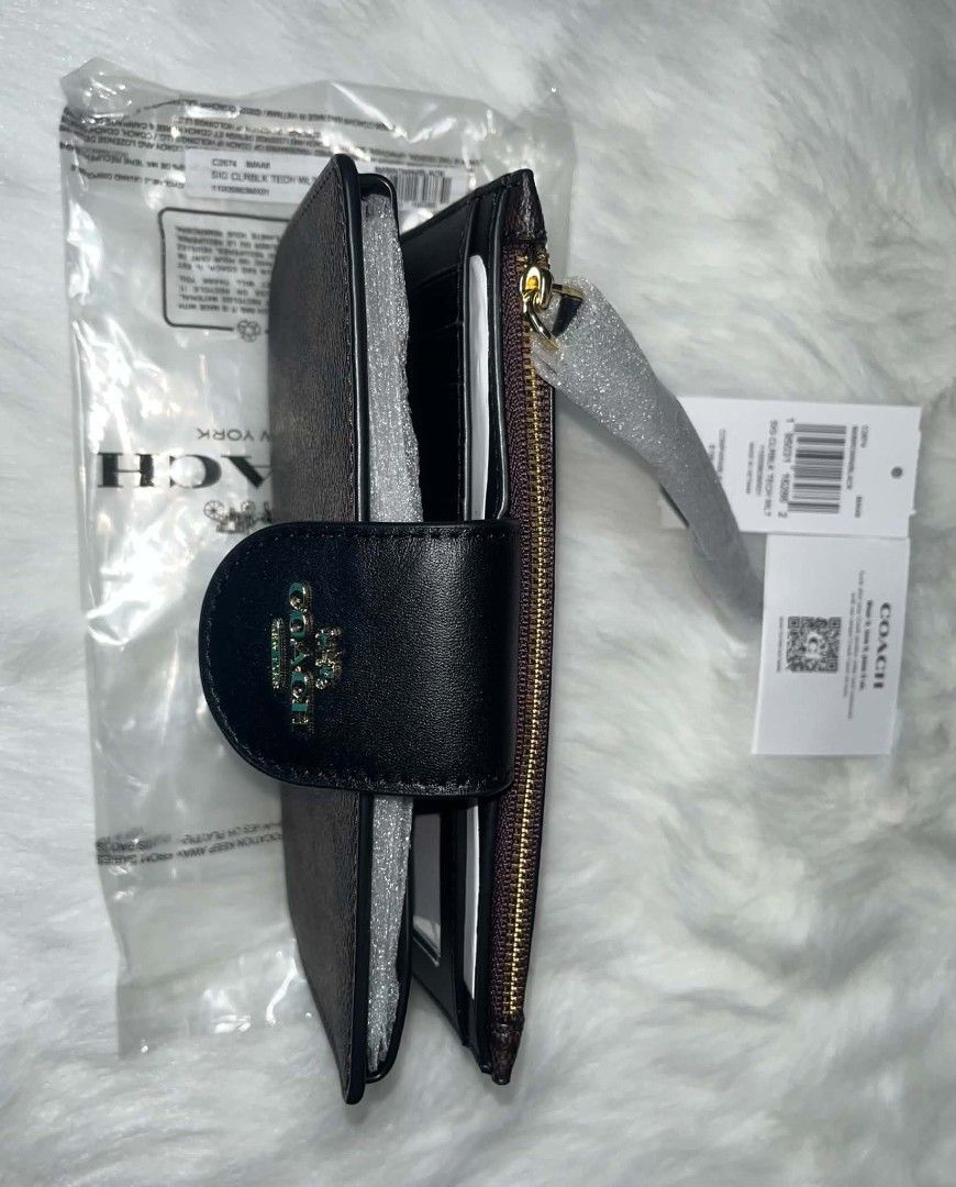 Coach Tech Phone Wallet Brown/Black (Category: Wallets & Card holders) located in Imus. Submitted by maria_pilayo (Listing ID 1470281656, Image 2). Description: - Brand: Coach - 💯% Authentic - Model: C2874 SIG CLRBLK TECH WLT - Colorway: Brown (Signature Colorblock) - Dimensions: 19cm (L) x 10.5cm (H) - Features: Multiple card slots and convenient wrist strap - Condition: Brand new in plastic packaging - Inclusions: Original tags and care card i